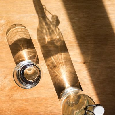 Glass of water on a table in sunny room.